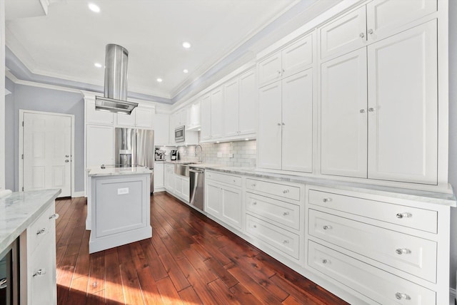 kitchen with white cabinetry, light stone counters, ornamental molding, a kitchen island, and stainless steel appliances