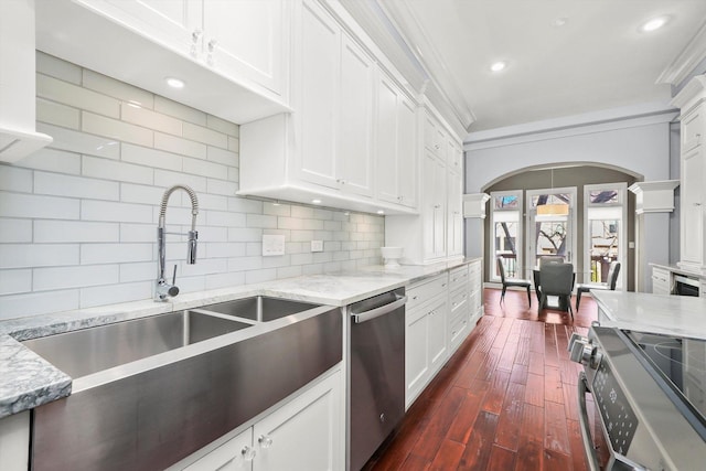 kitchen with light stone counters, ornamental molding, white cabinets, and appliances with stainless steel finishes