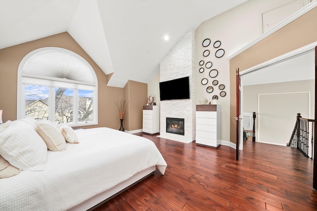 bedroom with lofted ceiling, a fireplace, and dark hardwood / wood-style floors