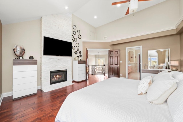 bedroom with ensuite bathroom, high vaulted ceiling, a fireplace, ceiling fan, and dark wood-type flooring