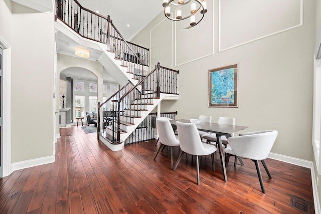 dining area featuring a high ceiling, dark hardwood / wood-style floors, and a chandelier