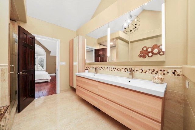 bathroom with vanity, lofted ceiling, and an inviting chandelier