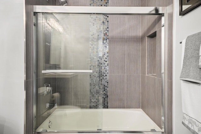 bathroom featuring combined bath / shower with glass door