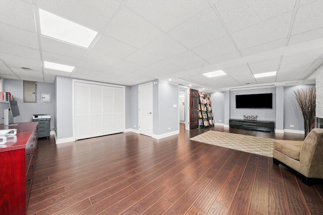 living room featuring dark hardwood / wood-style flooring and a drop ceiling