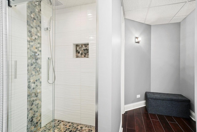 bathroom featuring a paneled ceiling and walk in shower