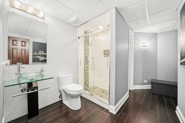 bathroom with vanity, a shower with shower door, toilet, and a paneled ceiling