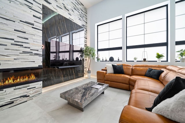 living room with a tiled fireplace and a wealth of natural light