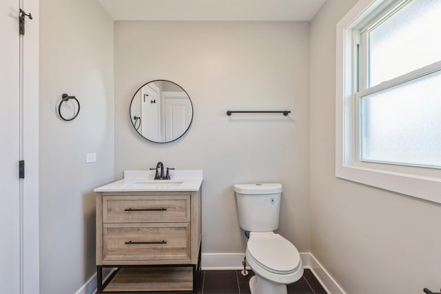 bathroom featuring toilet, tile patterned floors, a wealth of natural light, and vanity