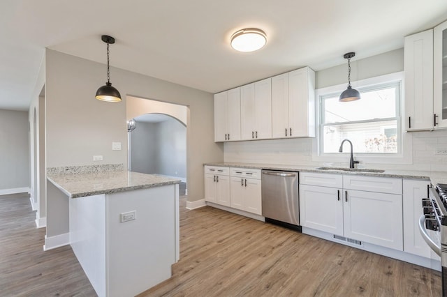 kitchen with kitchen peninsula, tasteful backsplash, white cabinetry, and appliances with stainless steel finishes