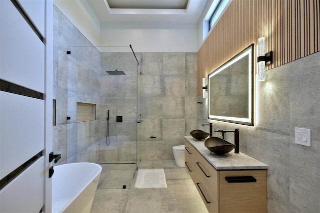 full bathroom featuring tile walls, toilet, vanity, and independent shower and bath