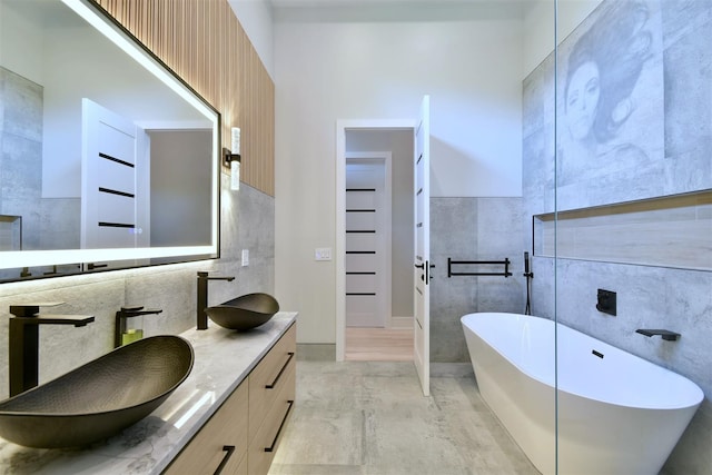 bathroom featuring a bathtub, tile walls, and vanity