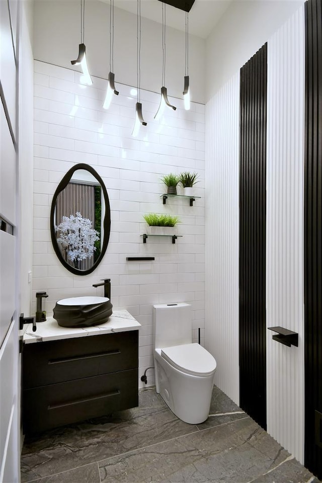 bathroom featuring tile walls, toilet, and vanity