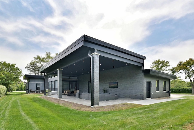 back of house featuring a patio area and a lawn