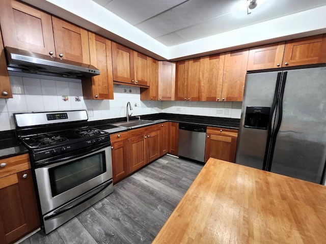 kitchen with stainless steel appliances, tasteful backsplash, sink, and butcher block countertops