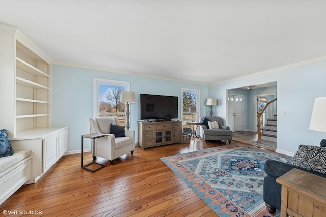 living room featuring ornamental molding, light hardwood / wood-style floors, and a wealth of natural light