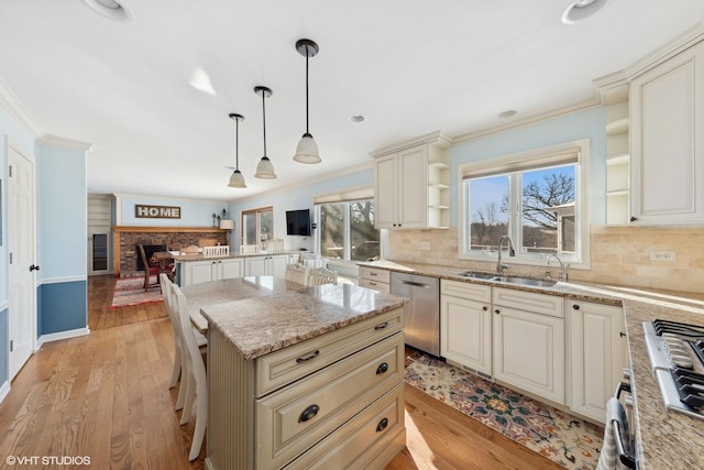 kitchen with sink, dishwasher, hanging light fixtures, light stone counters, and a kitchen island