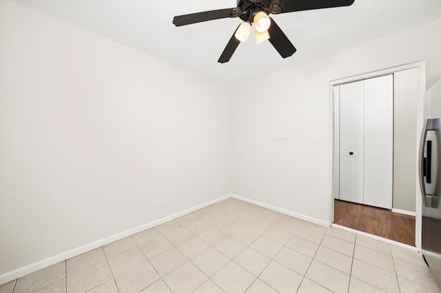 unfurnished bedroom with ceiling fan, light tile patterned floors, and a closet