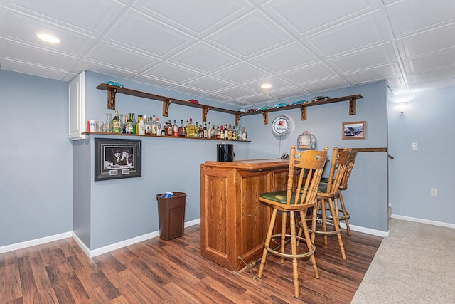 bar featuring white cabinetry and dark hardwood / wood-style flooring