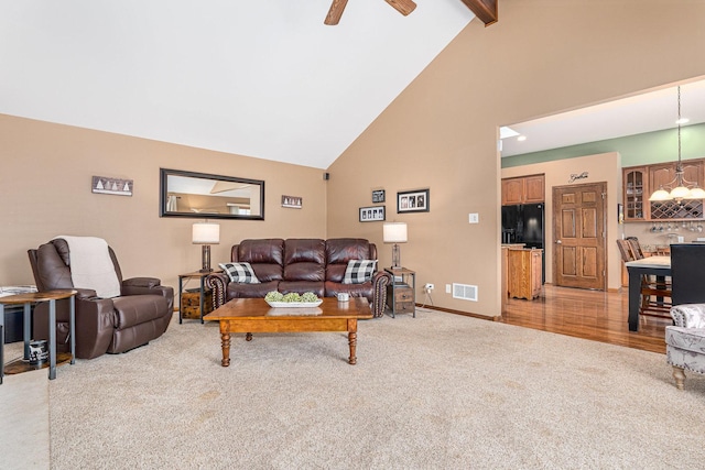 living room with high vaulted ceiling, ceiling fan, beamed ceiling, and carpet flooring