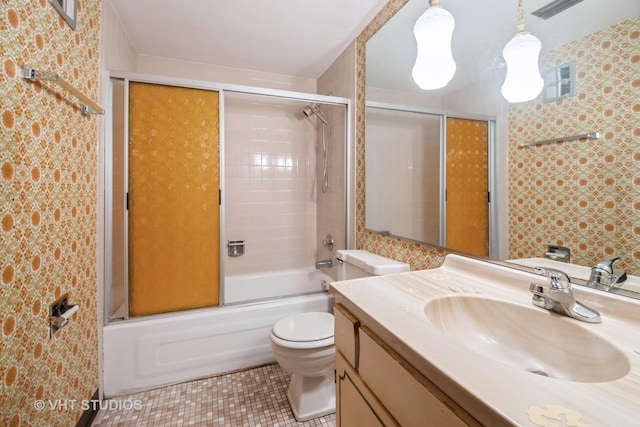 full bathroom featuring vanity, tile patterned floors, shower / bath combination with glass door, and toilet