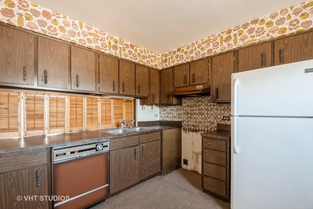 kitchen featuring tasteful backsplash, sink, dishwasher, and white refrigerator