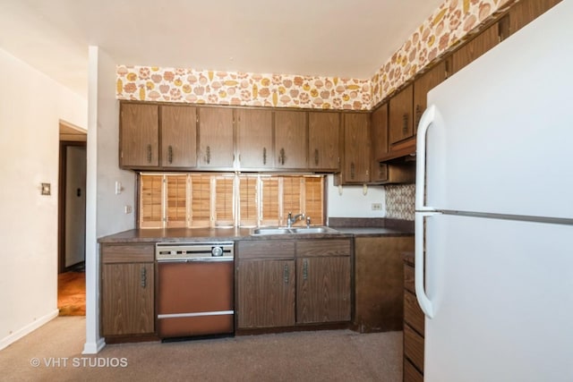 kitchen featuring dark carpet, dishwasher, sink, and white fridge