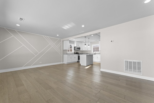 unfurnished living room with sink and wood-type flooring