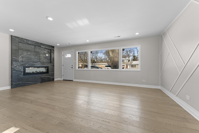 unfurnished living room featuring hardwood / wood-style floors and a tile fireplace