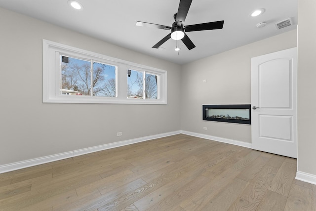 spare room featuring light hardwood / wood-style floors and ceiling fan