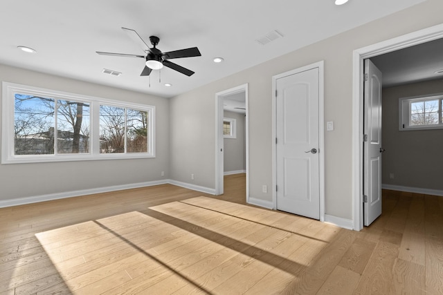 unfurnished bedroom with multiple windows, light hardwood / wood-style flooring, and ceiling fan