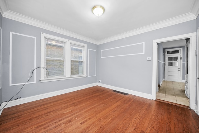 spare room with crown molding and hardwood / wood-style floors