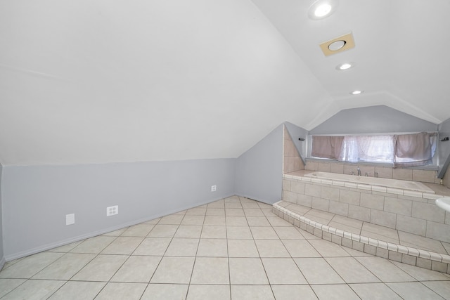 bathroom with tile patterned floors, a tub to relax in, and vaulted ceiling