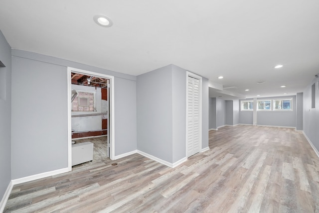 basement with light hardwood / wood-style flooring