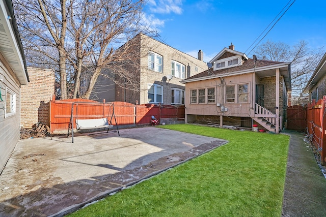 rear view of property featuring a patio and a yard