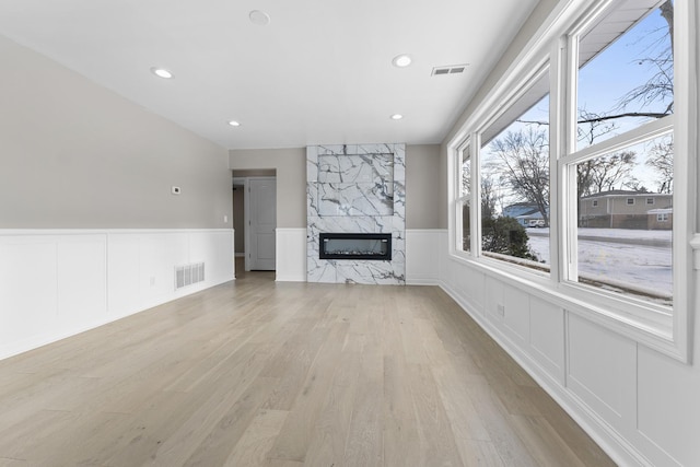 unfurnished living room featuring light hardwood / wood-style floors and a premium fireplace