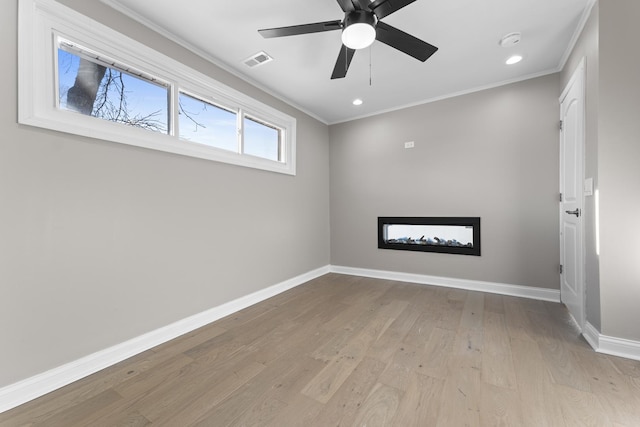 spare room with ceiling fan, ornamental molding, and light hardwood / wood-style floors