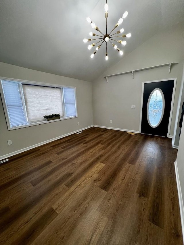 foyer entrance with a chandelier, dark hardwood / wood-style floors, and lofted ceiling