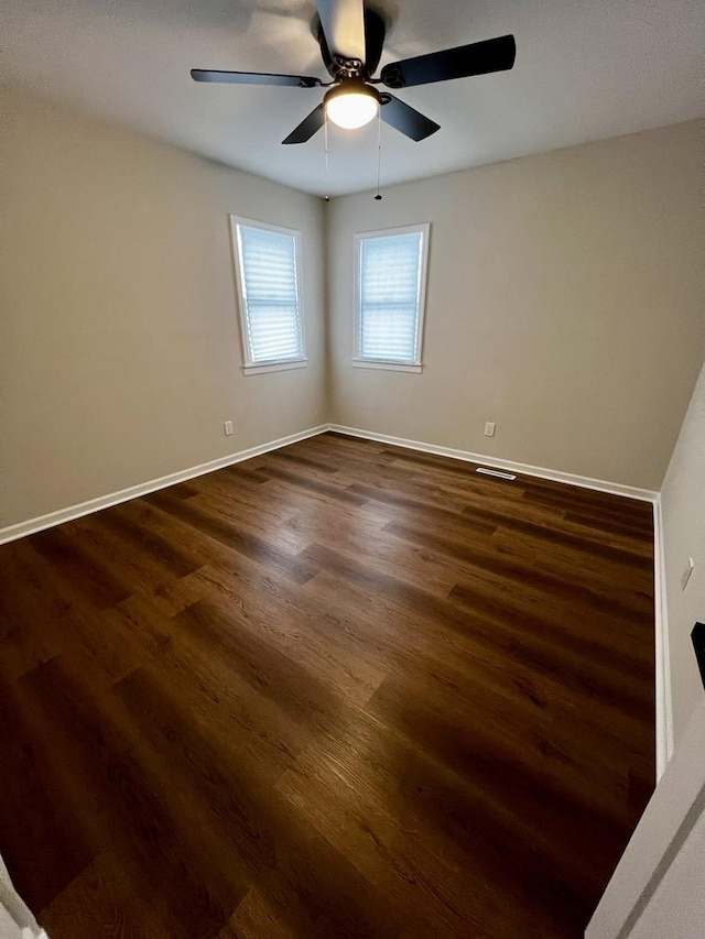 empty room featuring ceiling fan and dark hardwood / wood-style flooring