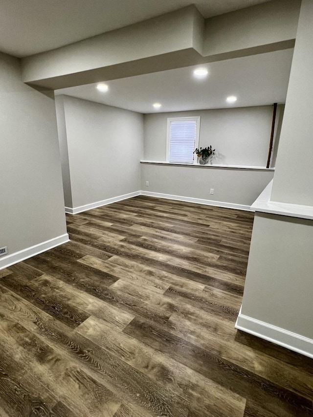 basement with dark hardwood / wood-style floors