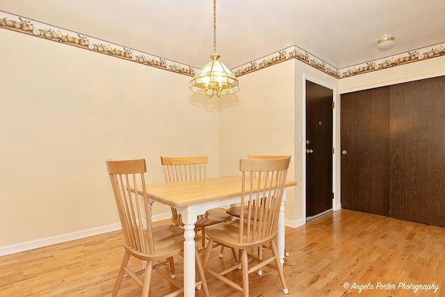 dining area with wood-type flooring and an inviting chandelier