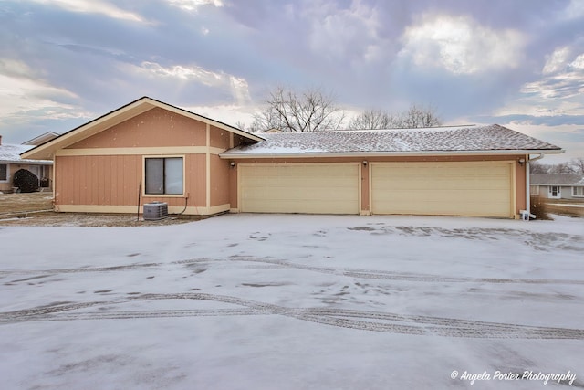 view of front of house with a garage and central air condition unit