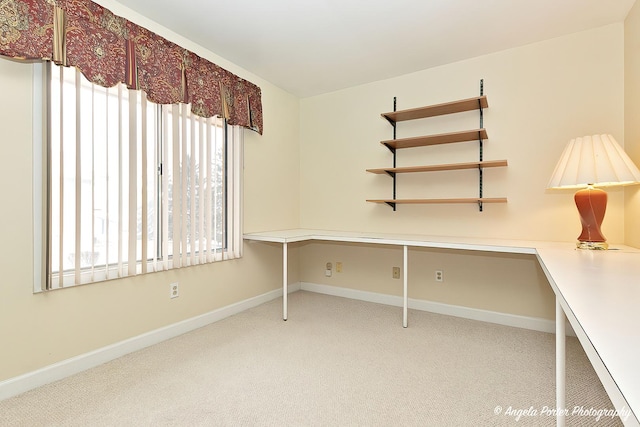 unfurnished office with light carpet and built in desk