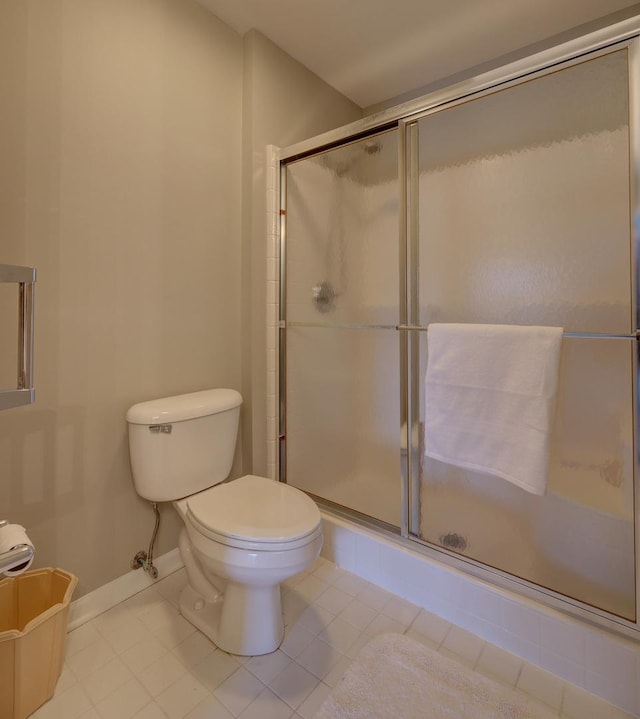 bathroom with toilet, tile patterned flooring, and an enclosed shower