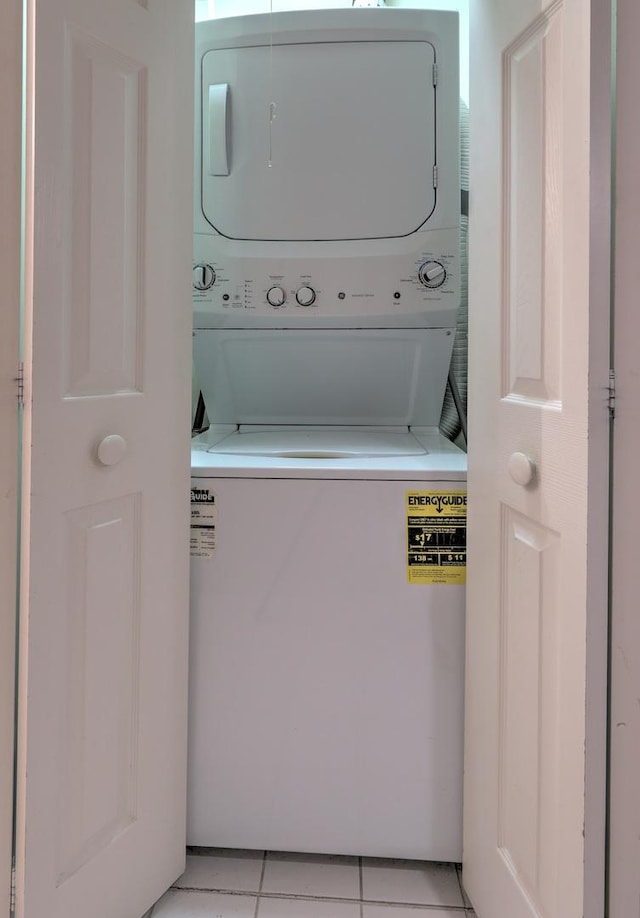 clothes washing area featuring light tile patterned floors and stacked washer / drying machine