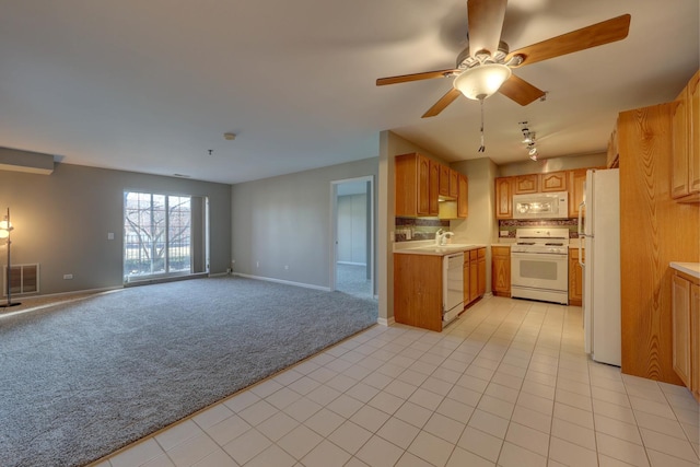 kitchen featuring sink, ceiling fan, white appliances, and light carpet