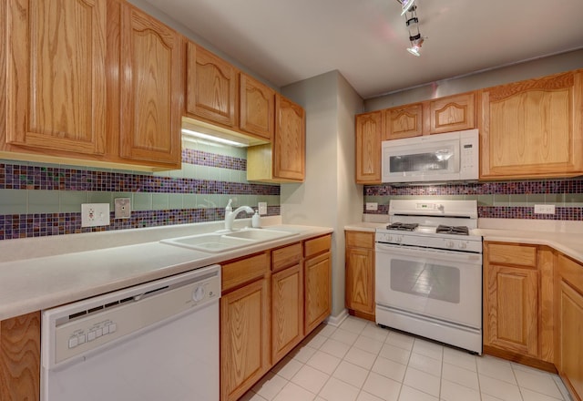 kitchen with sink, white appliances, tasteful backsplash, and light tile patterned floors