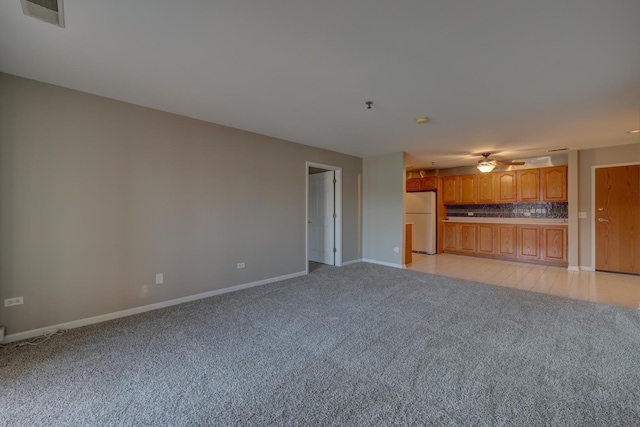 unfurnished living room featuring ceiling fan and light colored carpet