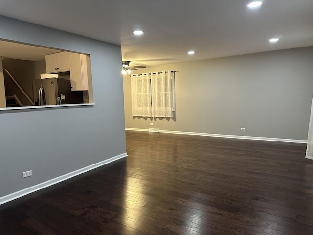 spare room featuring ceiling fan and dark wood-type flooring