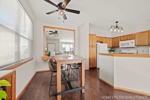 kitchen featuring pendant lighting, white appliances, and dark wood-type flooring