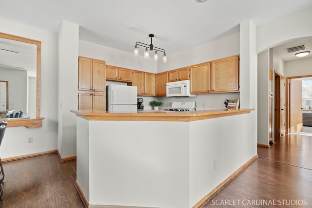 kitchen featuring hanging light fixtures, dark hardwood / wood-style floors, light brown cabinetry, and white appliances